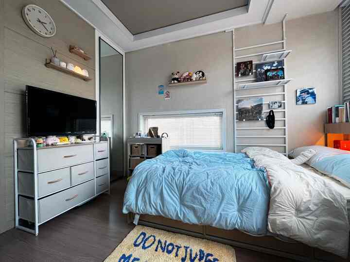 White and blue toned bedroom featuring shelves and blinds with a cozy atmosphere