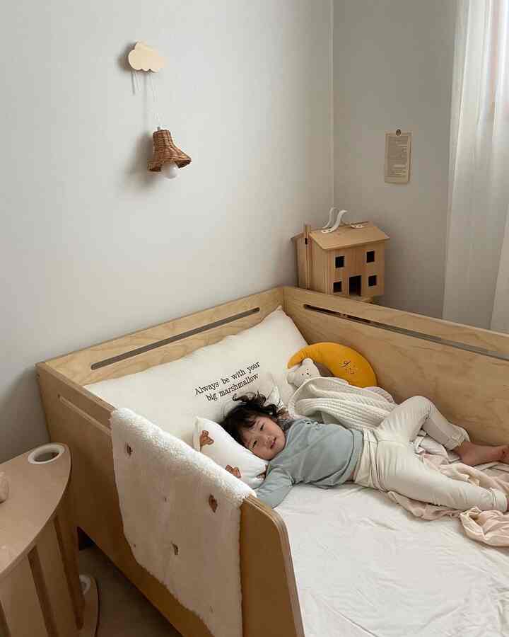 Natural wood tones with beige and white colors in a baby bedroom, featuring soft cushions and a cozy crib creating a warm atmosphere