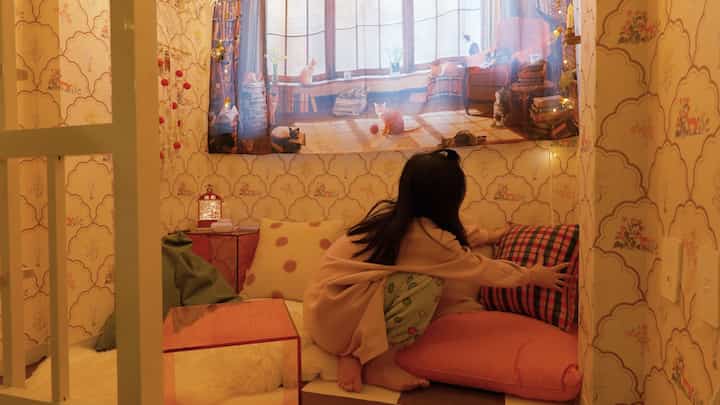 Cozy small kids' room in warm beige and orange tones featuring bean bags and various cushions