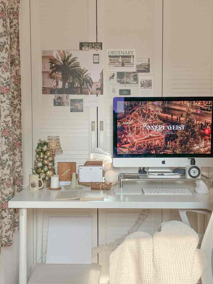 A white and wood-tone home office space featuring a desk neatly arranged with wooden accessories and a computer