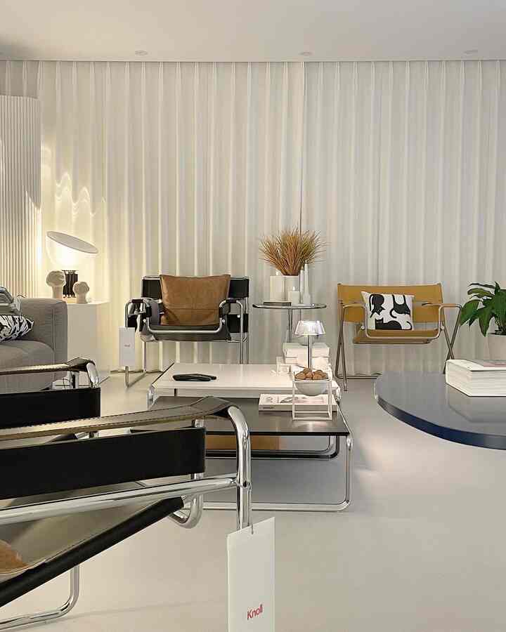 White and brown toned living room featuring modern armchairs, coffee table, and table lamps with a simple and natural atmosphere