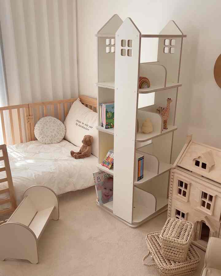 Beige and white toned kids' room featuring a baby crib and toy storage with a cozy atmosphere