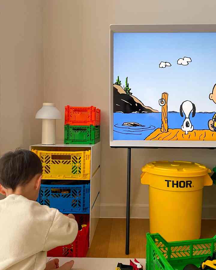 Bright yellow and blue storage boxes with a child in a living room, clean and minimal ambiance