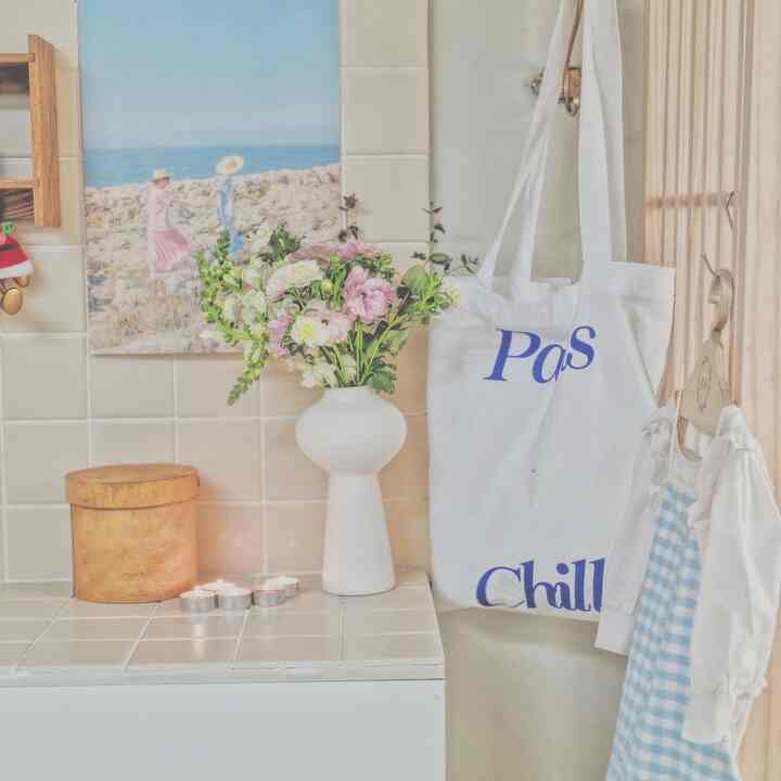 White and beige toned kitchen featuring a ceramic vase with flowers and lit candles, creating a cozy decor
