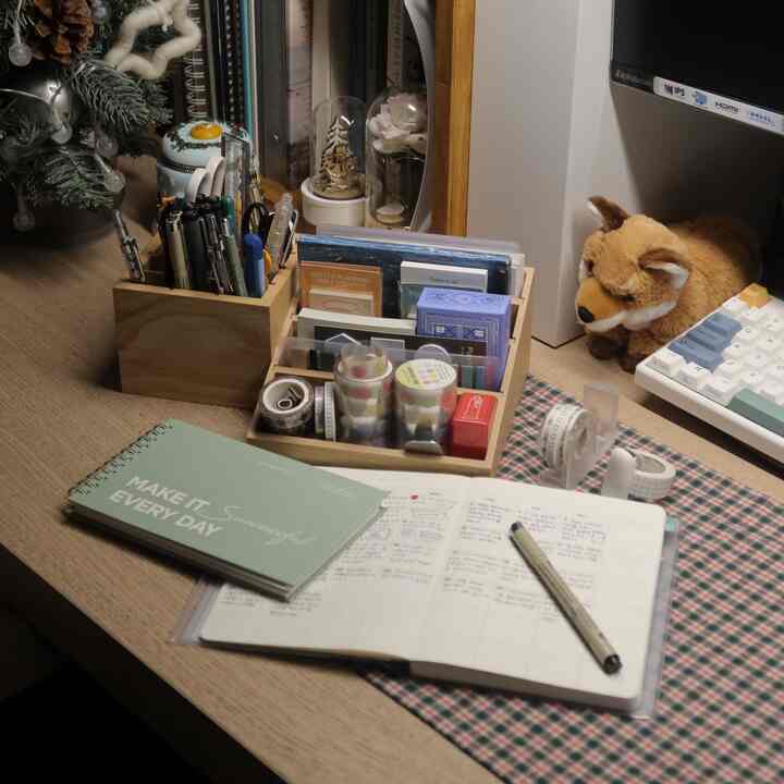 Warm wood-tone and white keyboard harmonize in a home office diary decoration zone, neatly arranged diary and stationery on desk