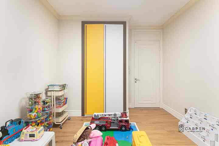 Natural beige and wood tones kids' room featuring built-in closet and neatly organized toys creating a cozy atmosphere