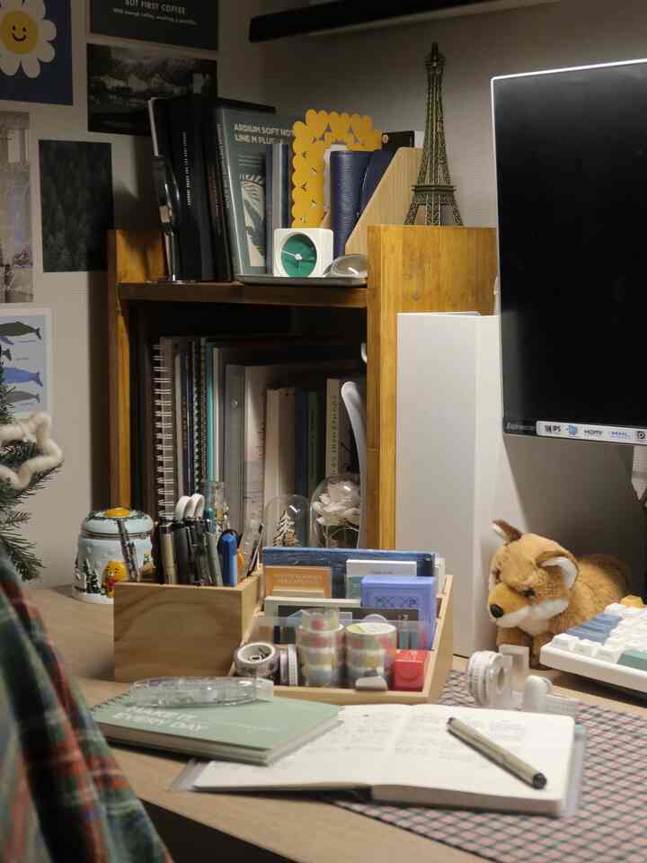 A warm wood-toned and white desk space featuring a bookshelf and cute decorative items showcasing a cozy desk interior decor.