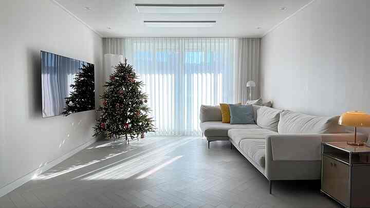 明るいホワイトトーンのリビング、広々としたソファとクリスマスツリーが配置された印象的な空間