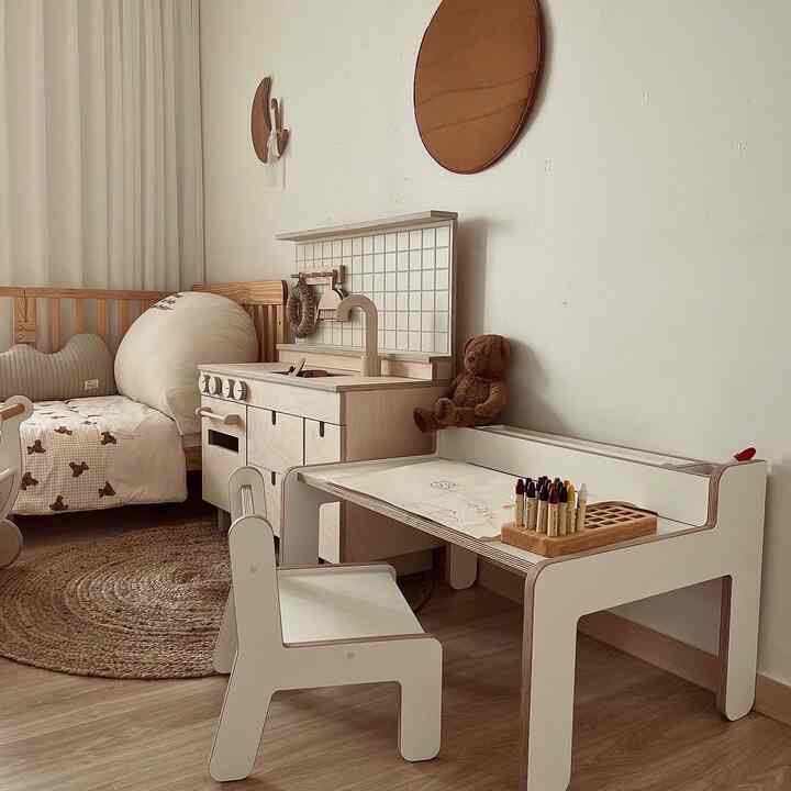 Natural-toned kids' room featuring a wooden children's desk and a round rattan rug with a cozy atmosphere