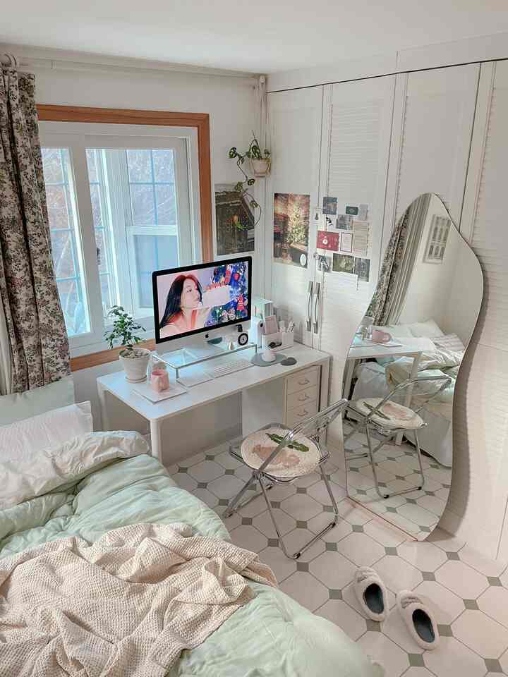 Bright bedroom with white and mint tones, featuring a full-length mirror and transparent folding chair in a clean and cozy setting