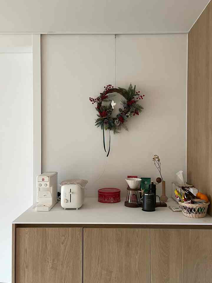 White and wood tone kitchen space featuring coffee machine and toaster with a neat home cafe atmosphere