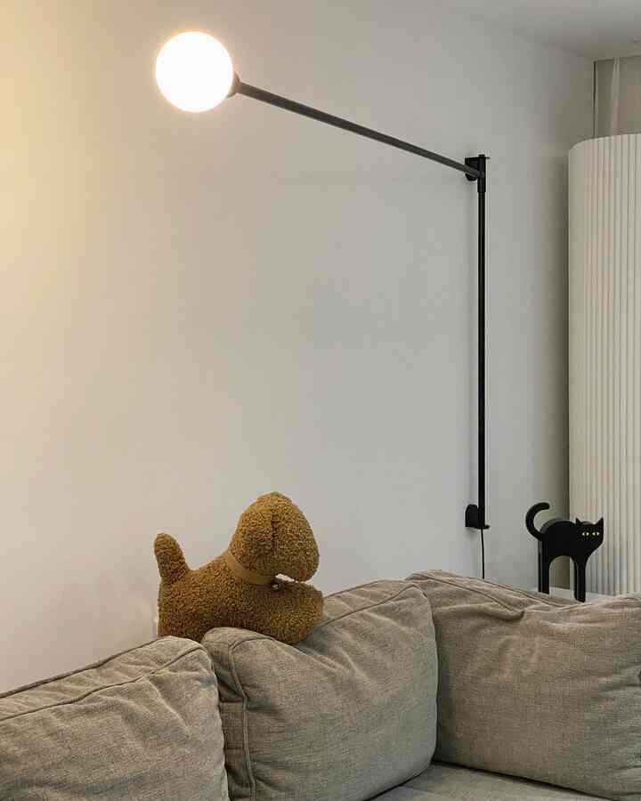 Gray sofa and wall sconce in a mid-century modern style living room with cozy pet-themed decor