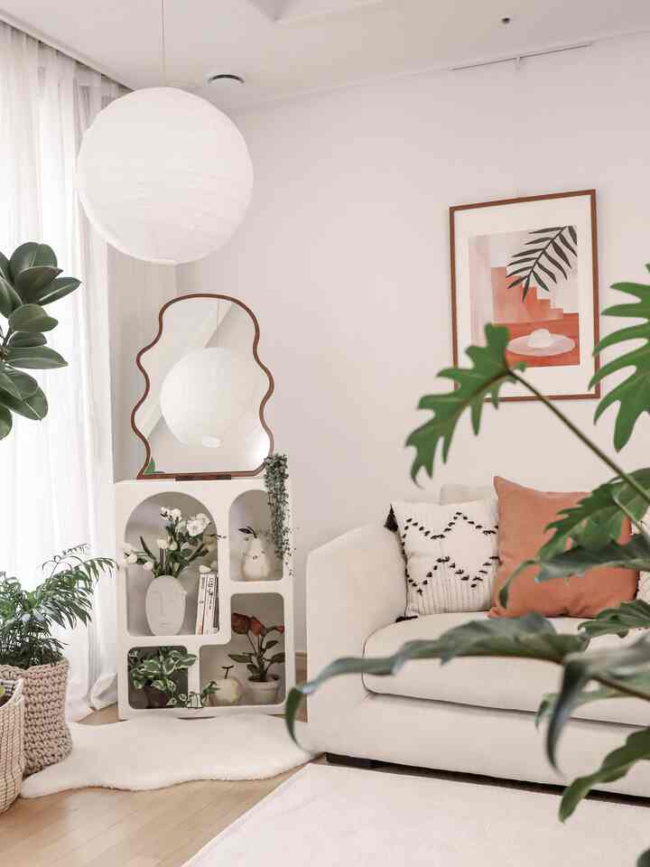 White and brown toned living room featuring Nordic style shelf and plants with a simple and natural atmosphere