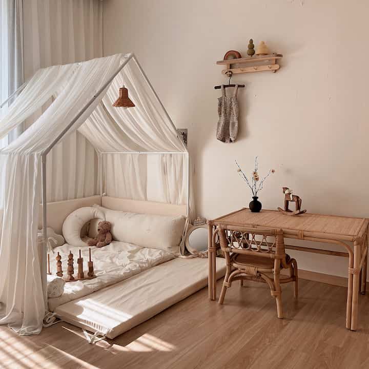 ナチュラルなベージュ調の子供部屋、ハウステント型のベビーベッドと木製家具が配置された雰囲気のあるインテリア