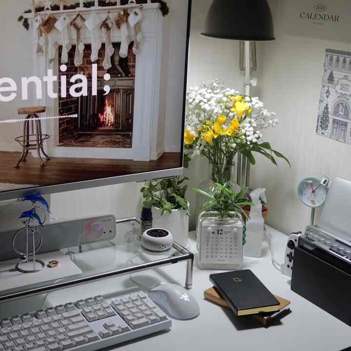 白を基調としたホームオフィス空間、整然としたデスクと植物が配置された落ち着いた作業環境