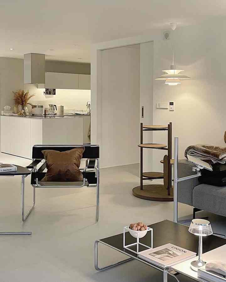 Natural-toned living room featuring mid-century modern armchair and pendant lighting with a clean, minimalist interior