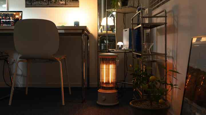 アイボリー調のホームオフィス、カーボンヒーターと移動式棚が配置された暖かい雰囲気のインテリア