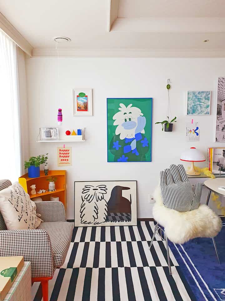 Bright and modern living room featuring a white and black striped rug and Mid-Century Modern armchair