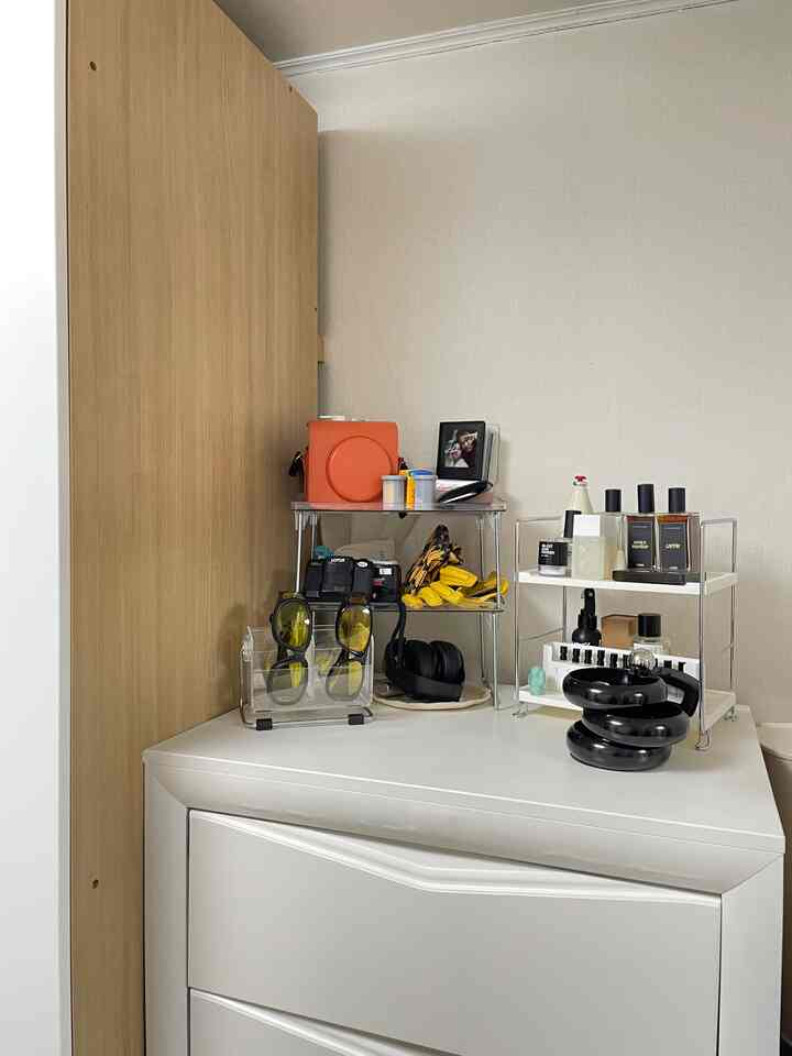 A clean storage corner featuring white cabinets and wood-tone wall panel with shelves and organizers neatly arranged