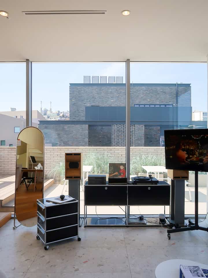 Black and white toned living room with dresser and shelf placed before large window, modern interior