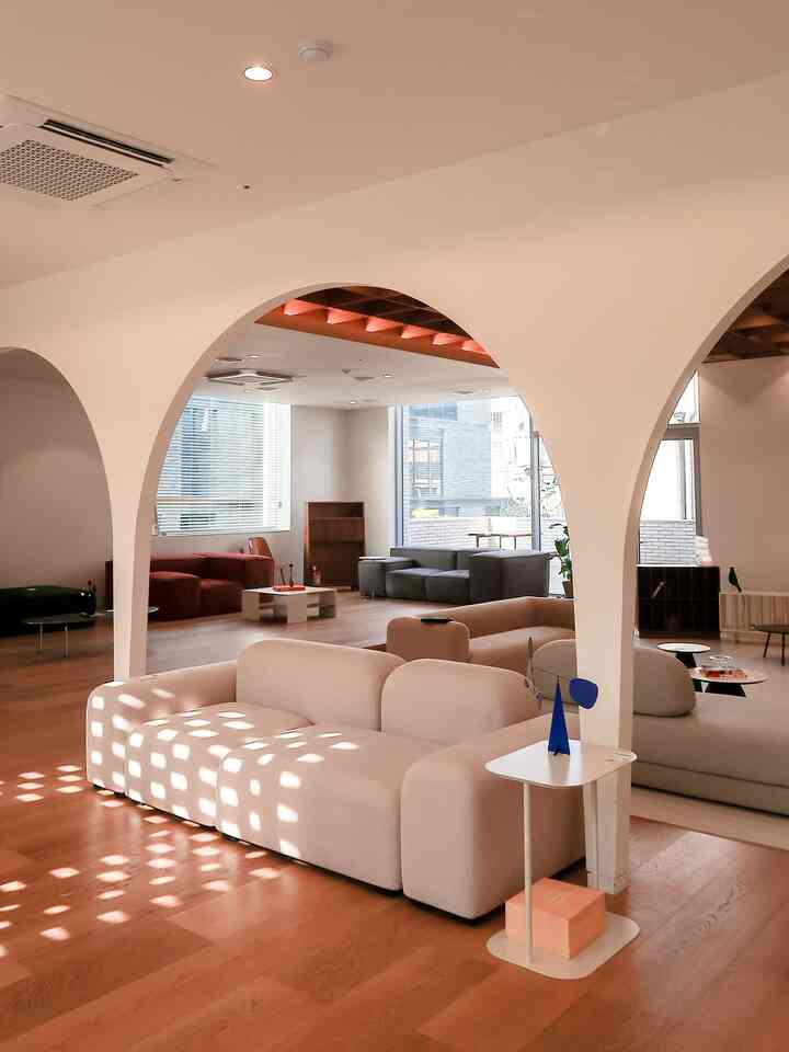 Natural color and wood tone living room featuring beige sofa and arched walls with warm modern atmosphere