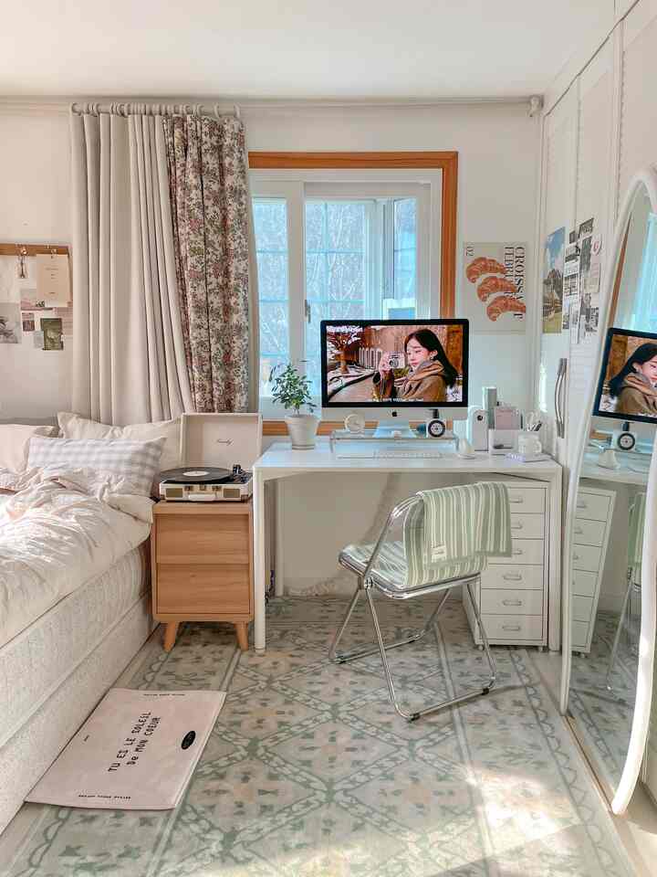 White and natural-toned bedroom and home office space featuring a computer desk, rug, and dresser with cozy atmosphere