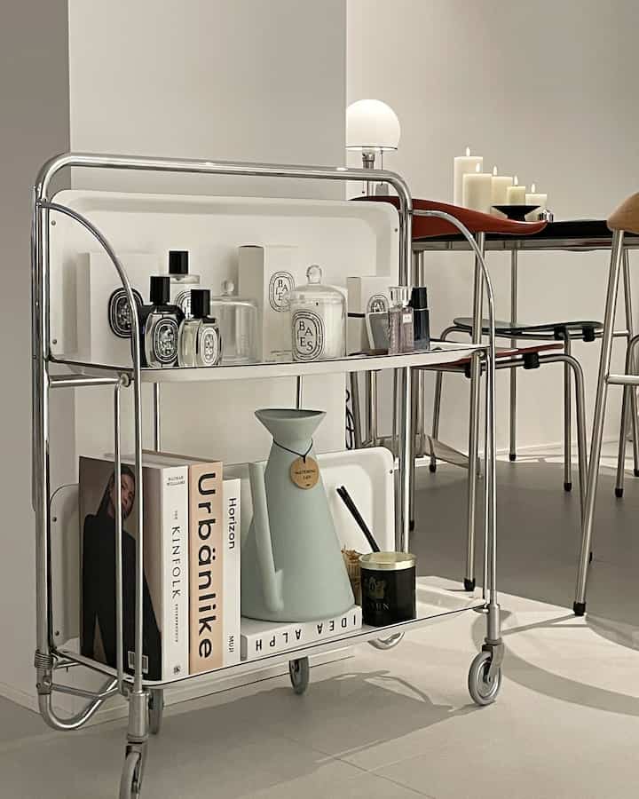White and brown toned kitchen featuring Mid-Century Modern trolley with glass bottles and candles in a stylish interior