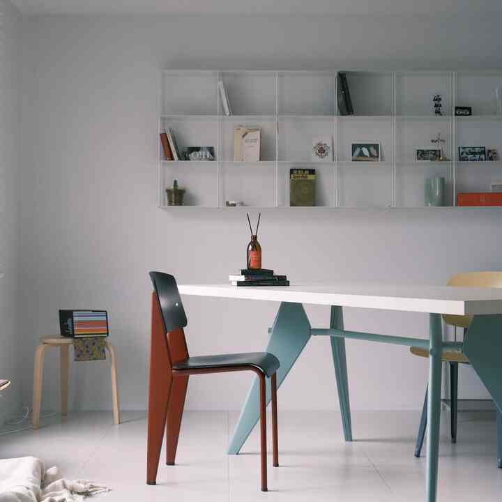 白とスカイブルーの色調のダイニング、中央にディフューザーと本が配置されたモダンなインテリア空間