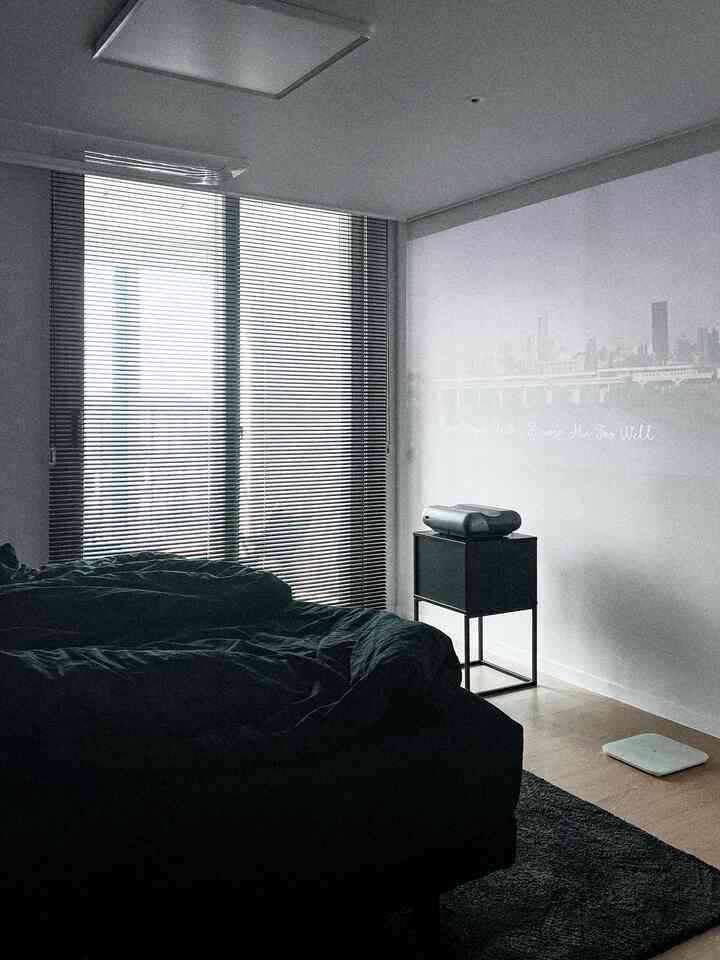 Black-toned bedroom featuring blinds and a projector with a modern, simple atmosphere