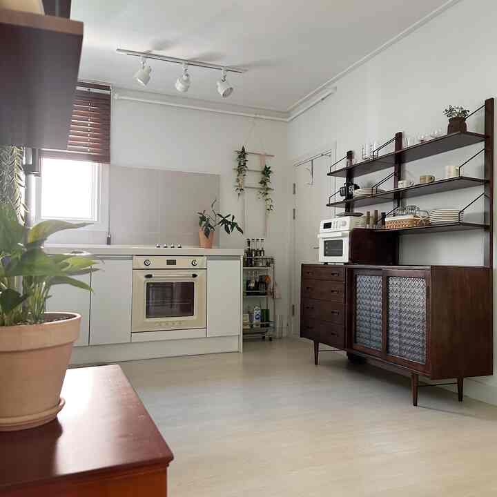A bright kitchen with white walls and wood-tone furniture featuring a Delma wide storage cabinet and SMEG oven for a clean interior