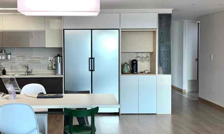 Modern kitchen home cafe with silver refrigerator and wood tone flooring, featuring a Nespresso machine and Delonghi kettle