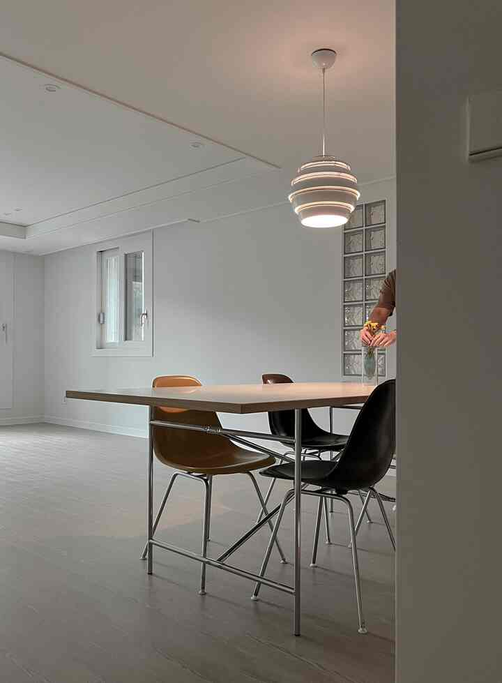 White-toned dining room featuring brown and black chairs with a simple modern atmosphere
