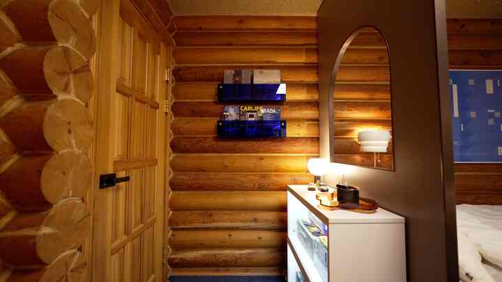 Warm wood-tone entrance featuring white cabinet, blue magazine racks, and an arch-shaped dark partition creating a cozy division