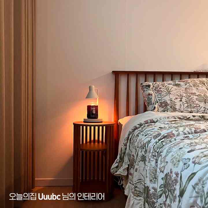 ベージュの壁とカーテン、木目調のベッドとナイトテーブルが配置された温かみのある寝室のインテリア