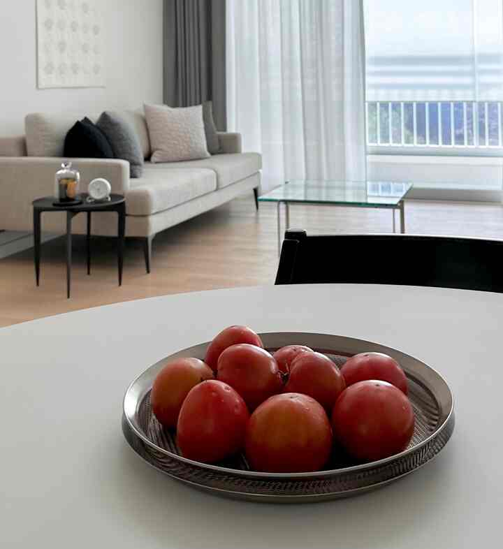 White and gray toned living room featuring beige sofa and glass coffee table with natural modern atmosphere