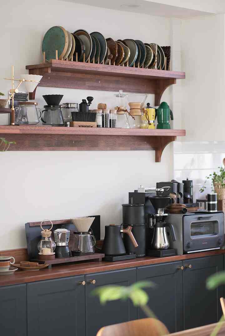 Modern kitchen home cafe featuring dark brown wooden shelves and black coffee equipment with a neat atmosphere