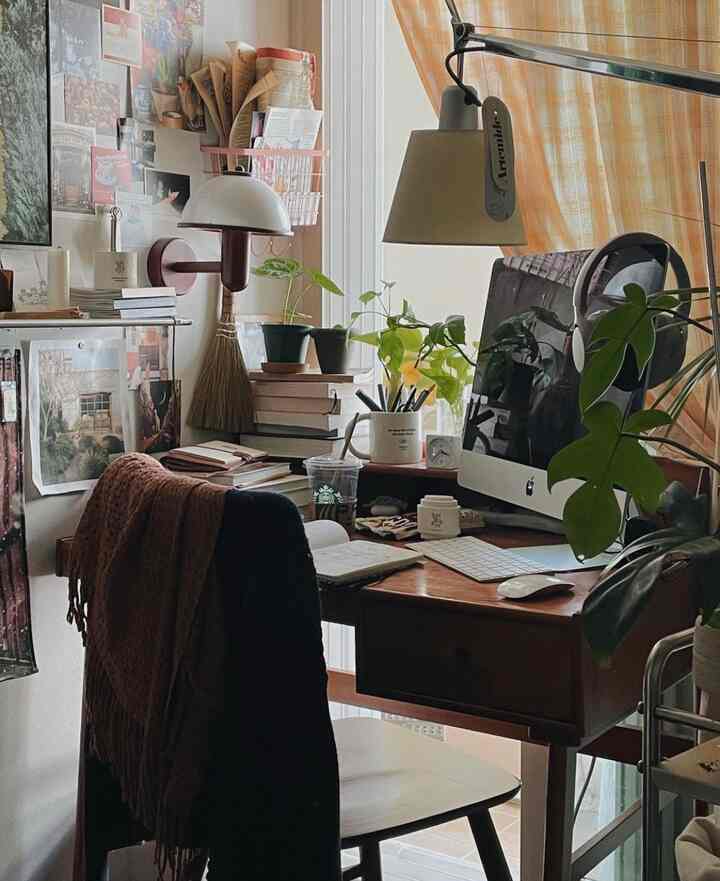 ナチュラルな色調のホームオフィス、デスクにコンピューターと植物が配置された居心地の良い空間