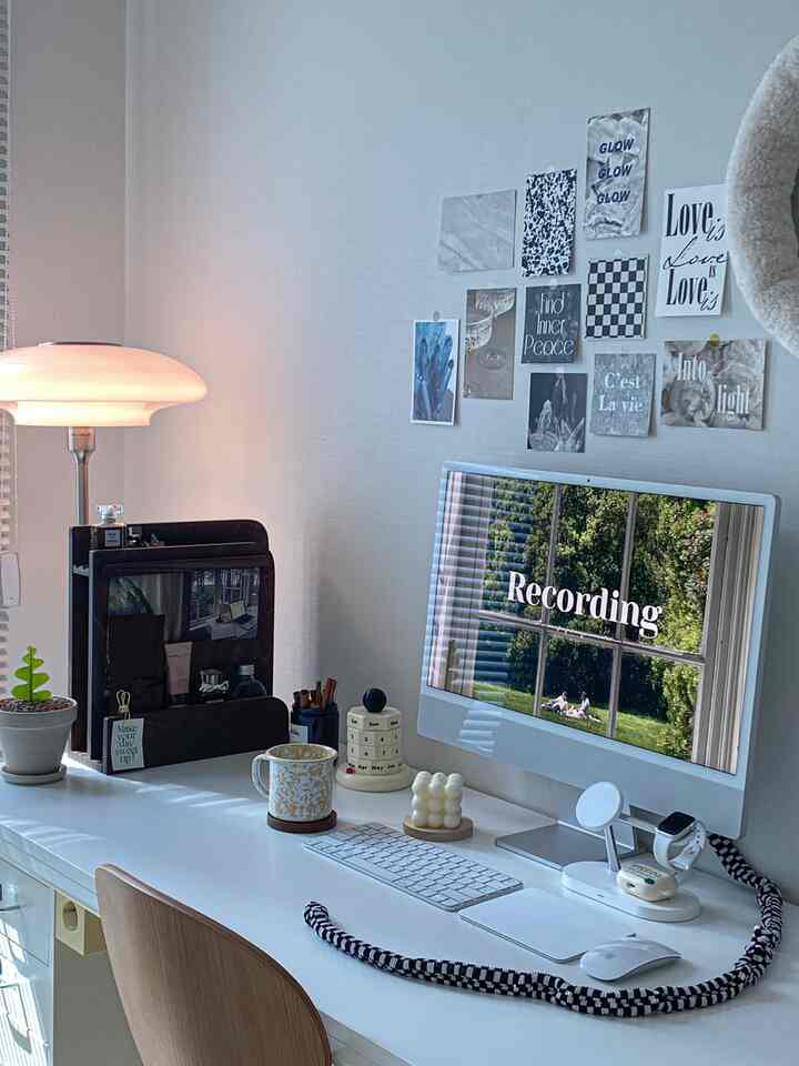 Bright white-toned study space featuring iMac and various posters in a neat home office interior