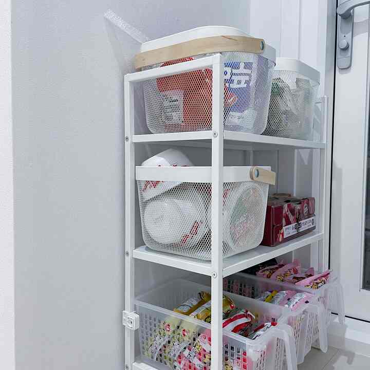 White-toned narrow veranda area featuring metal shelving and various storage baskets neatly arranged for practical storage