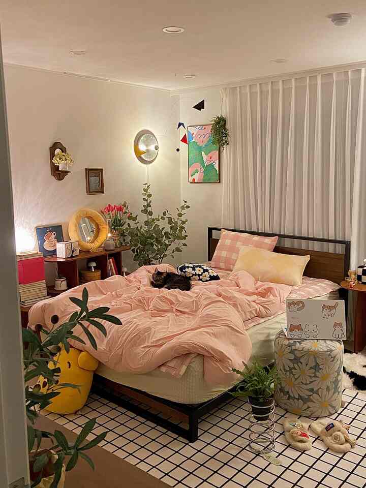 Pink-toned bedroom featuring soft duvet cover and a cat, creating a cozy and natural atmosphere