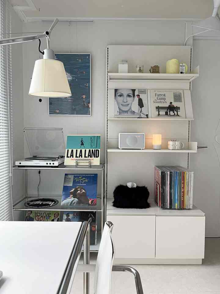 Living room music space with white and steel tones, featuring neat storage and a turntable in a simple modern style