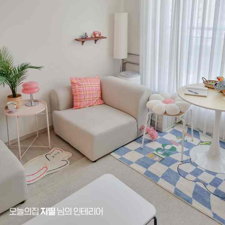 ホワイトとベージュの色調のリビング、シンプルでナチュラルなスタイルにかわいい小物が配置された印象的な空間