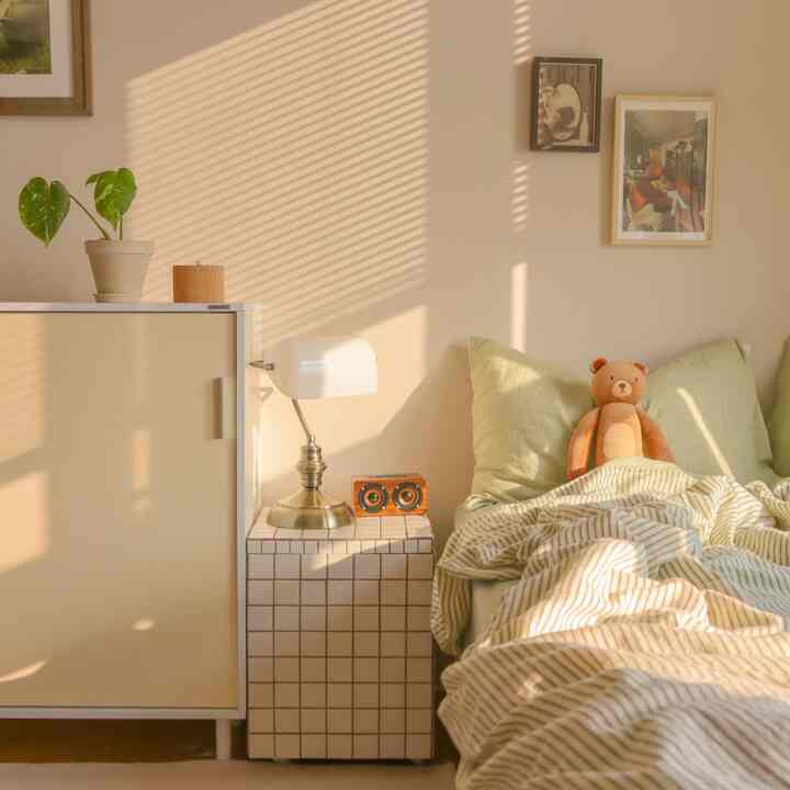 Cozy bedroom in white and brown tones featuring a tiled nightstand and wooden cabinet