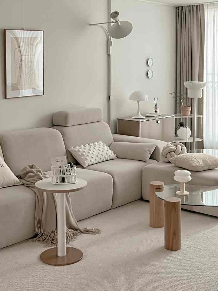 Bright beige natural-tone living room featuring spacious sofa and minimal furniture with a tidy atmosphere