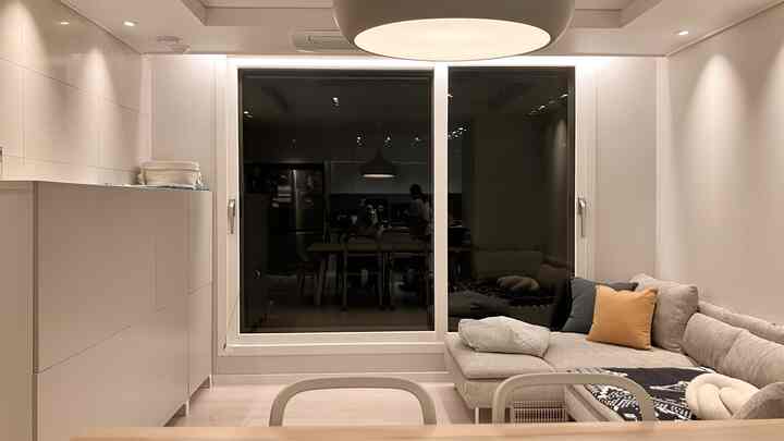 A light gray and white toned living room featuring a light gray sectional sofa and multifunctional storage, presenting a clean natural modern space