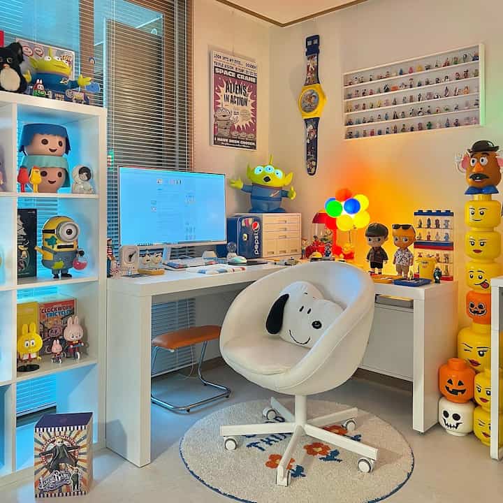 Bright white and blue toned kidult-themed home office featuring desk, playful collectible toys, and cozy atmosphere
