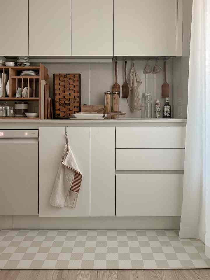 White and natural toned kitchen space featuring organized cutting boards and utensils with a clean, minimalist atmosphere