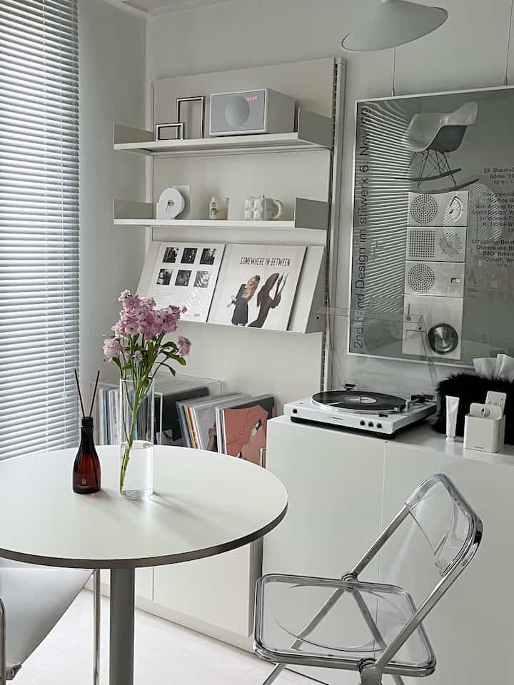 白と透明素材のミニマルなダイニングルーム、ターンテーブルとビニールLPが音楽鑑賞空間を演出している
