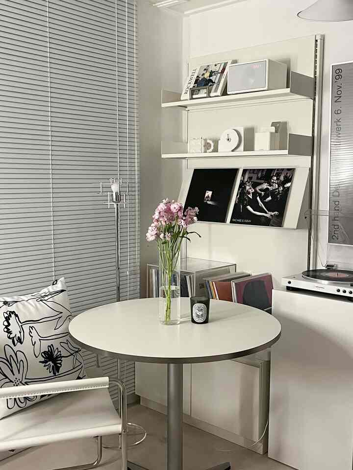 モノトーンのリビング、丸テーブルに花瓶とキャンドルが置かれたシンプルで落ち着いたホームバーの雰囲気あるインテリア