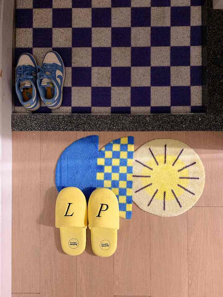 Entrance area with blue and yellow point colors, checkerboard floor tiles and yellow indoor slippers creating a cozy ambiance